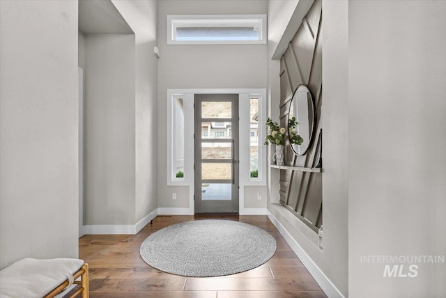 foyer entrance with wood finished floors and baseboards