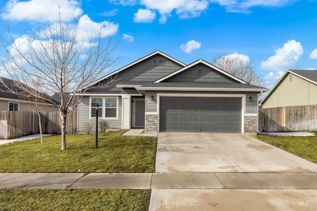 view of front of home with driveway, a garage, stone siding, fence, and a front lawn