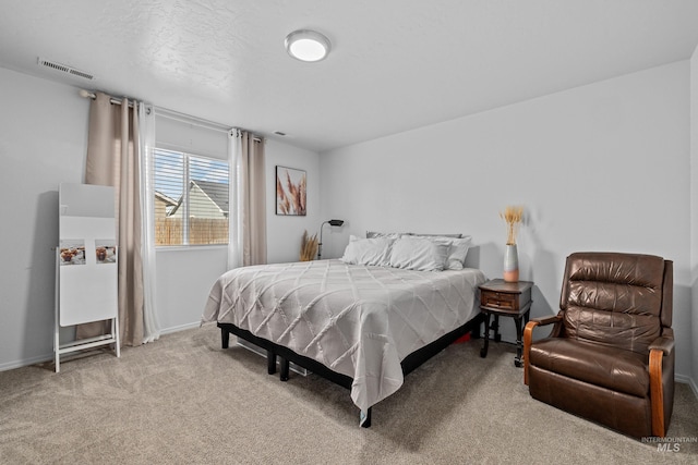 bedroom featuring a textured ceiling, carpet flooring, visible vents, and baseboards