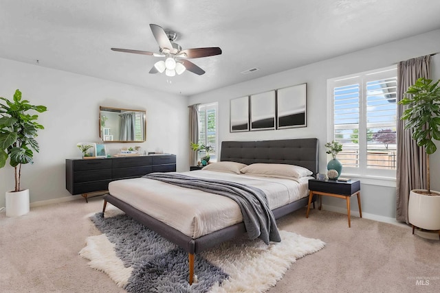 carpeted bedroom with a ceiling fan, baseboards, and visible vents