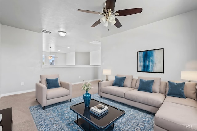 living room with baseboards, a ceiling fan, and visible vents