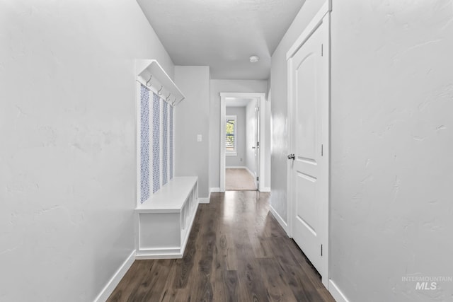 hall with baseboards and dark wood-style flooring
