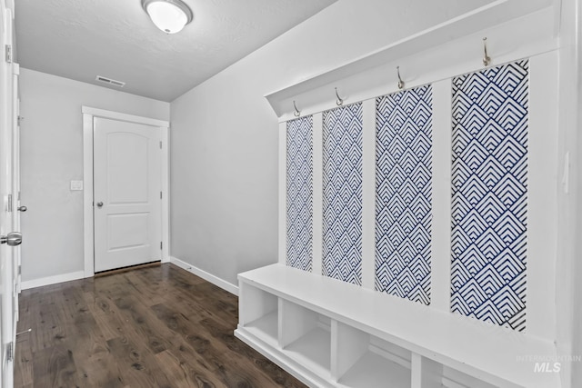 mudroom featuring baseboards, dark wood-type flooring, and visible vents