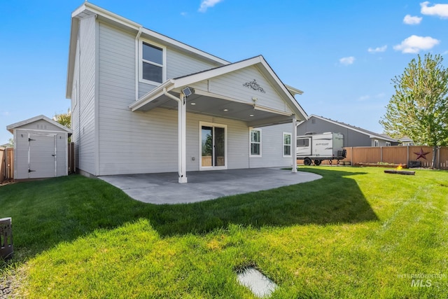 rear view of property featuring an outdoor structure, a patio, a fenced backyard, a shed, and a yard