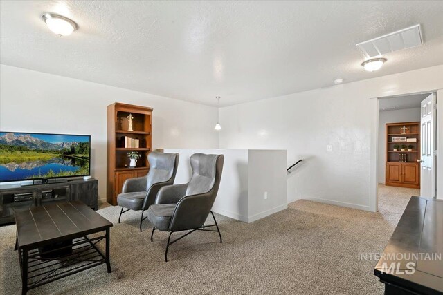 living room featuring light carpet, baseboards, built in features, and a textured ceiling