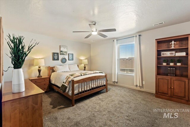 carpeted bedroom featuring a textured ceiling and a ceiling fan