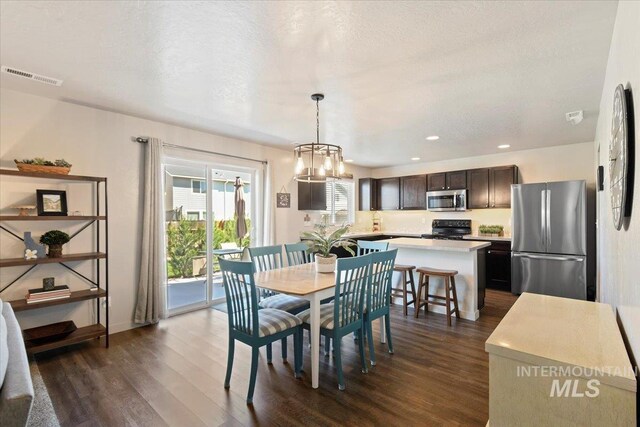 dining area with dark wood-type flooring, a chandelier, and recessed lighting