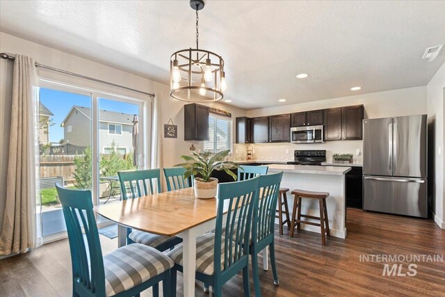 dining area with dark wood finished floors, recessed lighting, a chandelier, and a textured ceiling