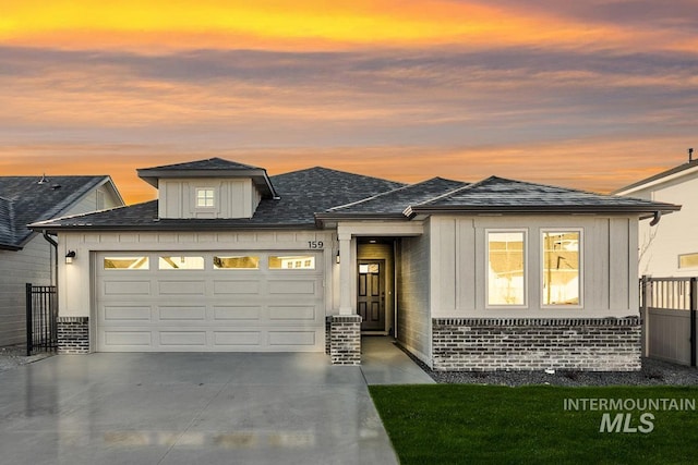 prairie-style house with an attached garage, driveway, and brick siding