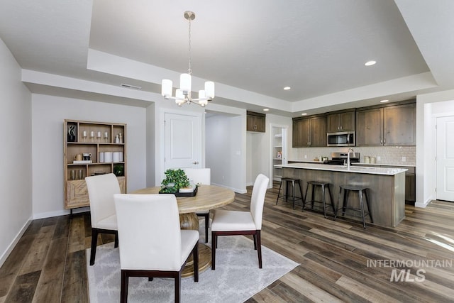 dining room with baseboards, a chandelier, and a tray ceiling