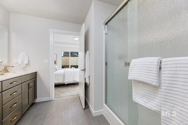 ensuite bathroom featuring baseboards, connected bathroom, and a shower stall