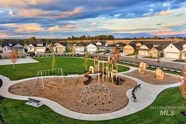 view of property's community featuring a yard, a residential view, and playground community