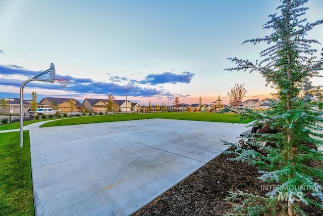 view of basketball court featuring a residential view, community basketball court, and a lawn