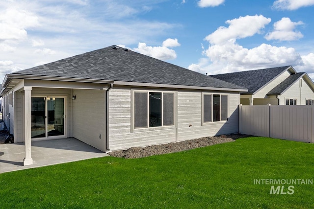 back of house featuring a yard, a patio, fence, and roof with shingles