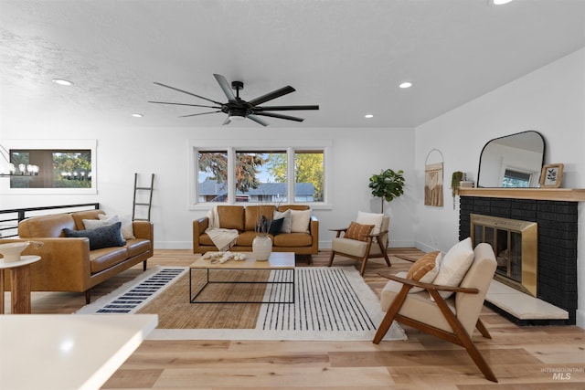 living room featuring recessed lighting, a brick fireplace, a textured ceiling, wood finished floors, and baseboards