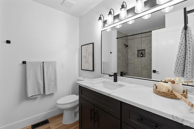 full bathroom with toilet, visible vents, wood finished floors, and vanity