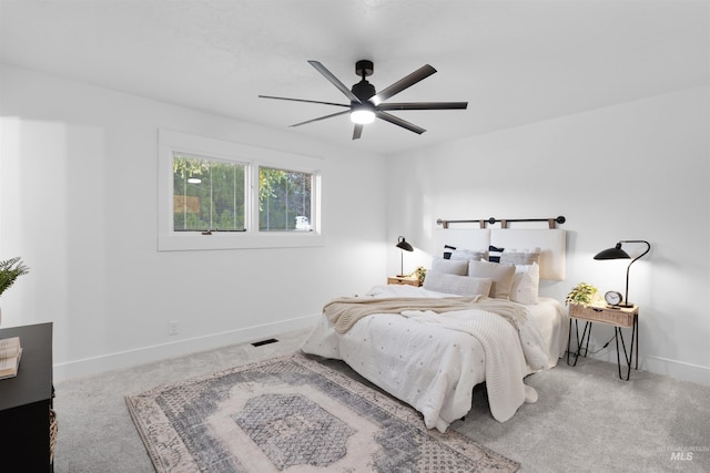 carpeted bedroom with a ceiling fan, visible vents, and baseboards