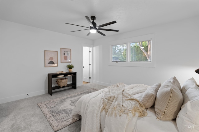 carpeted bedroom with ceiling fan and baseboards