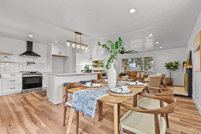 living room featuring plenty of natural light, light hardwood / wood-style floors, and a textured ceiling