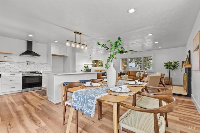 dining area featuring light wood-type flooring, a brick fireplace, and recessed lighting