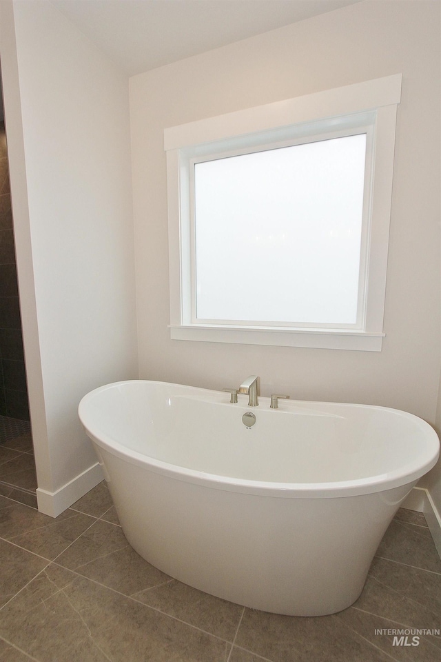 4658 S Hennessy Ave, Meridian, ID 83642 - bathroom with a freestanding tub, tile patterned floors, and baseboards