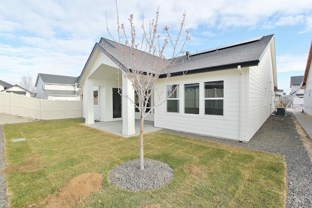 4658 S Hennessy Ave, Meridian, ID 83642 - back of property featuring a shingled roof, central AC unit, a patio area, a lawn, and fence