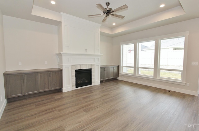 4658 S Hennessy Ave, Meridian, ID 83642 - unfurnished living room with baseboards, wood finished floors, a ceiling fan, and a tray ceiling