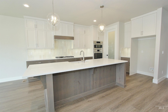 4658 S Hennessy Ave, Meridian, ID 83642 - kitchen featuring appliances with stainless steel finishes, white cabinetry, backsplash, and baseboards
