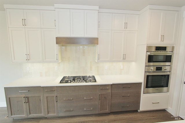 4658 S Hennessy Ave, Meridian, ID 83642 - kitchen featuring tasteful backsplash, dark wood-type flooring, light countertops, white cabinets, and appliances with stainless steel finishes