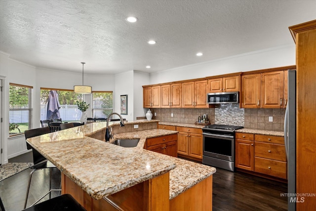 kitchen featuring sink, stainless steel appliances, and a kitchen island with sink