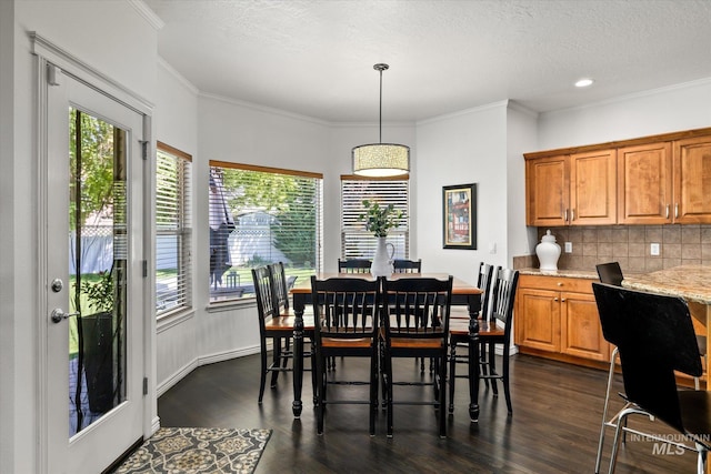 dining area featuring crown molding, dark wood-type flooring, and a textured ceiling