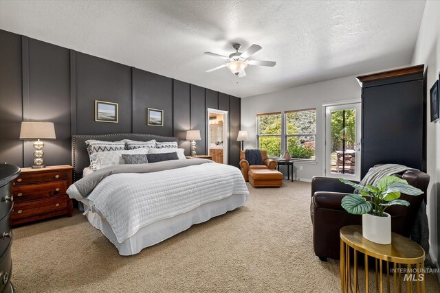 carpeted bedroom featuring a textured ceiling, ensuite bathroom, and ceiling fan