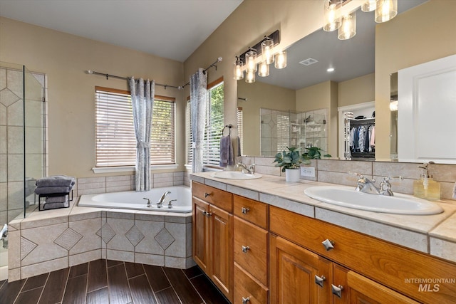 bathroom with vanity and shower with separate bathtub