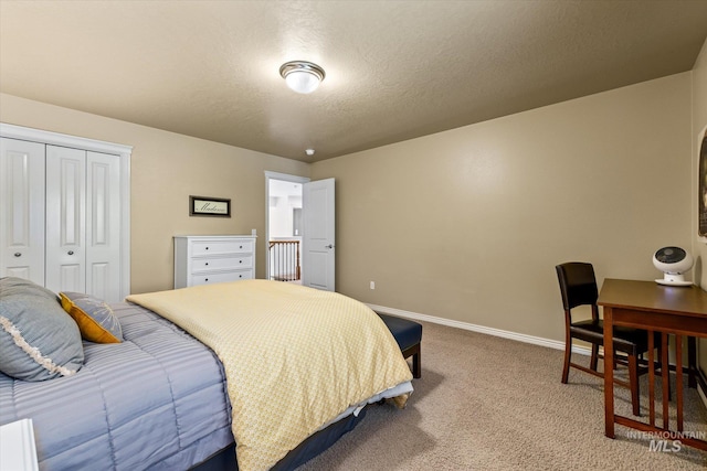 bedroom featuring a textured ceiling, carpet floors, and a closet