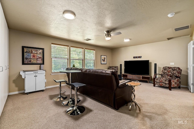 living room featuring light carpet, a textured ceiling, and ceiling fan