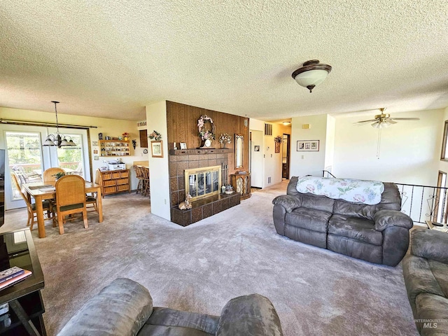 409 Garfield St, Asotin, WA 99402 - carpeted living room with a textured ceiling, a tiled fireplace, and a ceiling fan