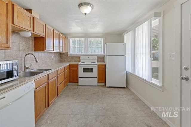 1324 E Oak St, Caldwell, ID 83605 - kitchen featuring white appliances, a sink, light countertops, tasteful backsplash, and brown cabinetry