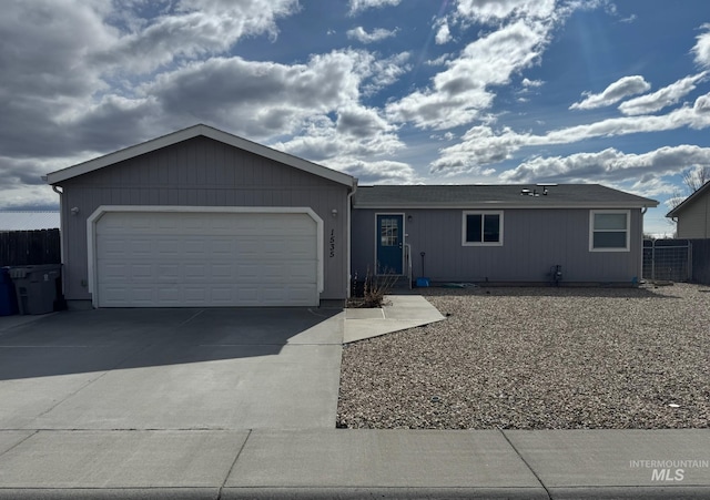 ranch-style home with driveway, an attached garage, and fence