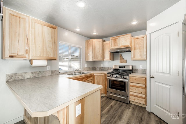 kitchen featuring dark wood-type flooring, light brown cabinetry, kitchen peninsula, and stainless steel gas range oven