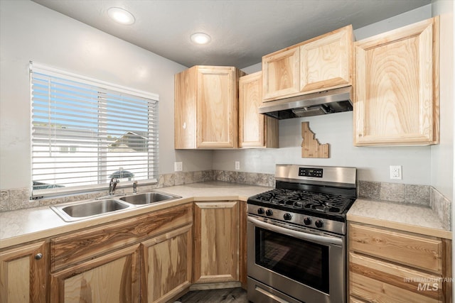 kitchen with gas stove, extractor fan, sink, and light brown cabinetry