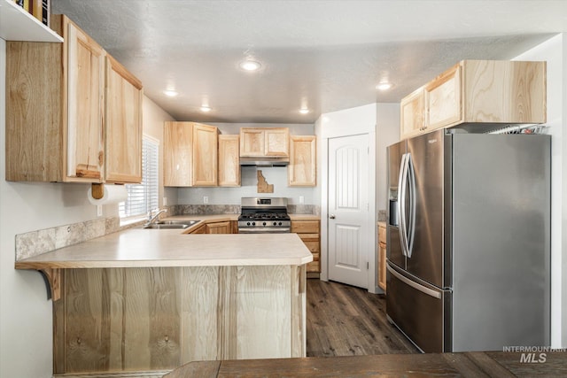 kitchen with sink, kitchen peninsula, light brown cabinetry, dark hardwood / wood-style flooring, and appliances with stainless steel finishes