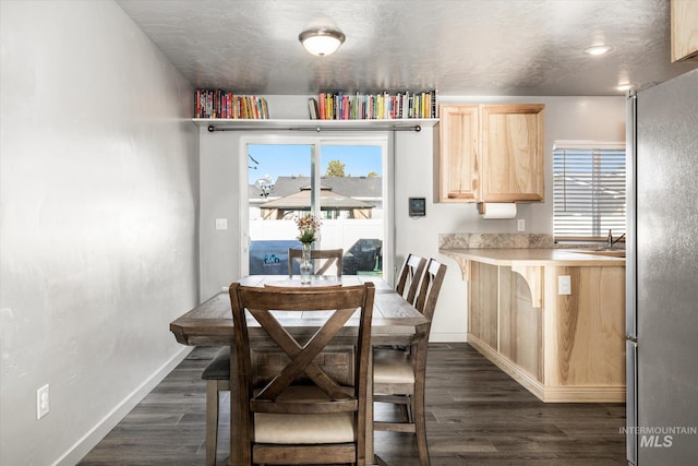 dining area featuring sink and dark hardwood / wood-style floors