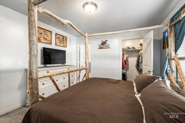 bedroom featuring a textured ceiling, a walk in closet, a closet, and carpet floors