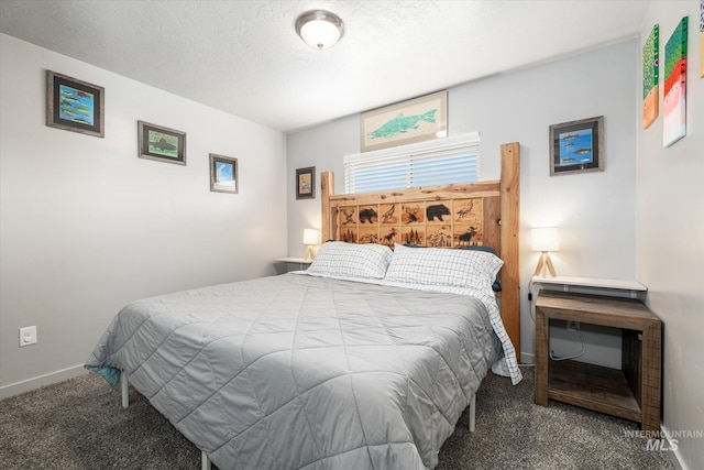 bedroom featuring a textured ceiling and dark carpet