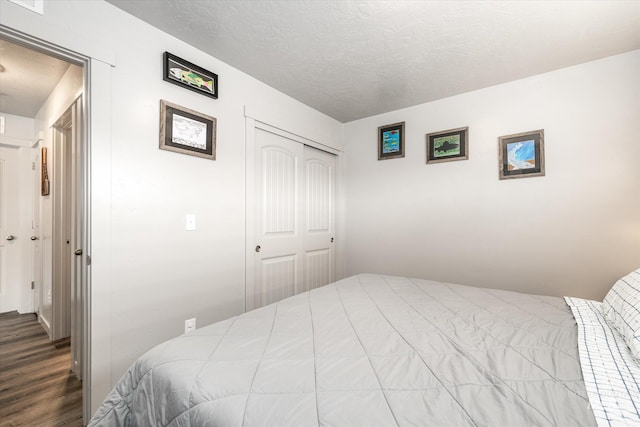 bedroom featuring a textured ceiling, a closet, and hardwood / wood-style flooring