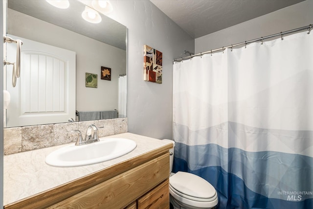 bathroom featuring toilet, a textured ceiling, a shower with shower curtain, and vanity