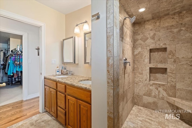 1640 S 5th W, Mountain Home, ID 83647 - full bathroom with double vanity, wood finished floors, tiled shower, and a spacious closet