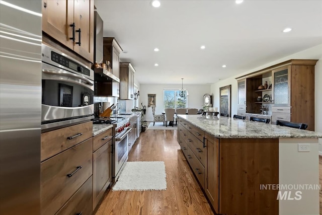 1640 S 5th W, Mountain Home, ID 83647 - kitchen featuring premium appliances, a kitchen island, wood finished floors, recessed lighting, and open shelves