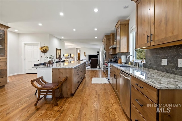 1640 S 5th W, Mountain Home, ID 83647 - kitchen featuring a sink, dishwasher, a kitchen island, light wood-type flooring, and a breakfast bar area