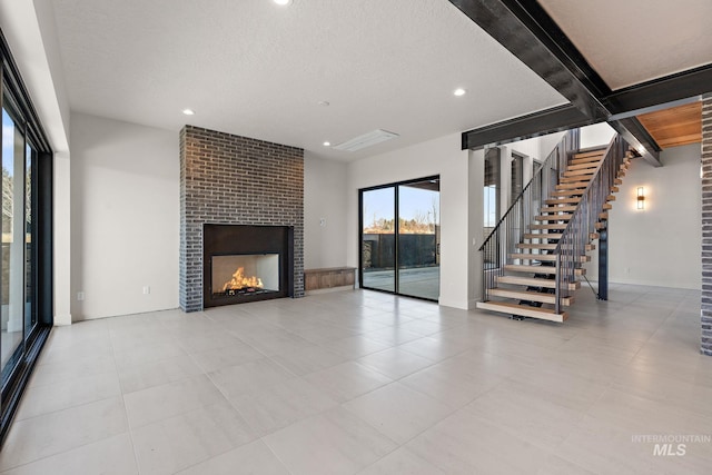 unfurnished living room featuring beam ceiling, a fireplace, and a textured ceiling